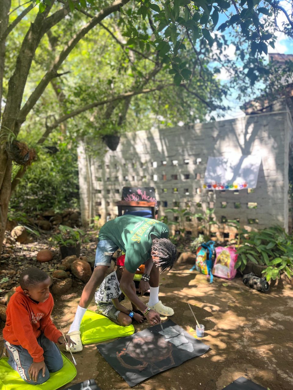 Miss Zee helping a child paint